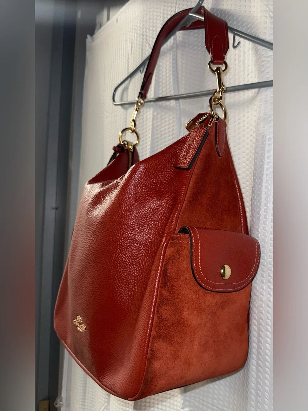 Coach Pennie Shoulder Bag features gold hardware and side suede pockets